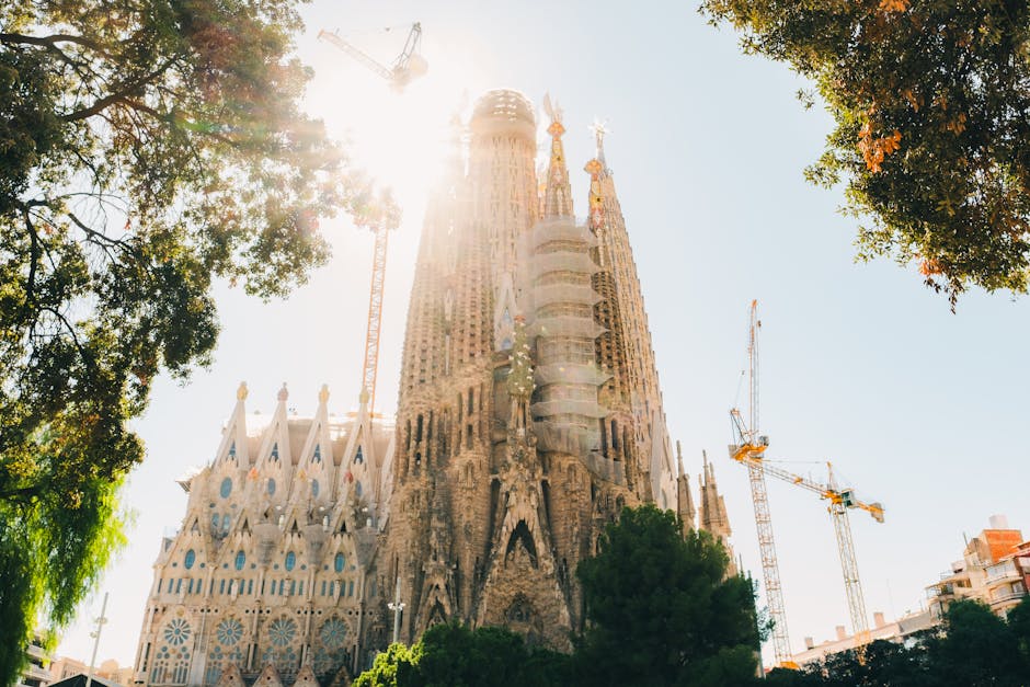 The Sagrada Familia at sunrise with golden light streaming over the towers