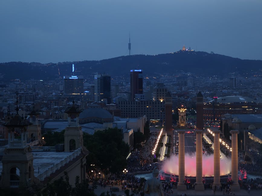 The Magic Fountain of Montjuic illuminated at night with the Palau Nacional in the background