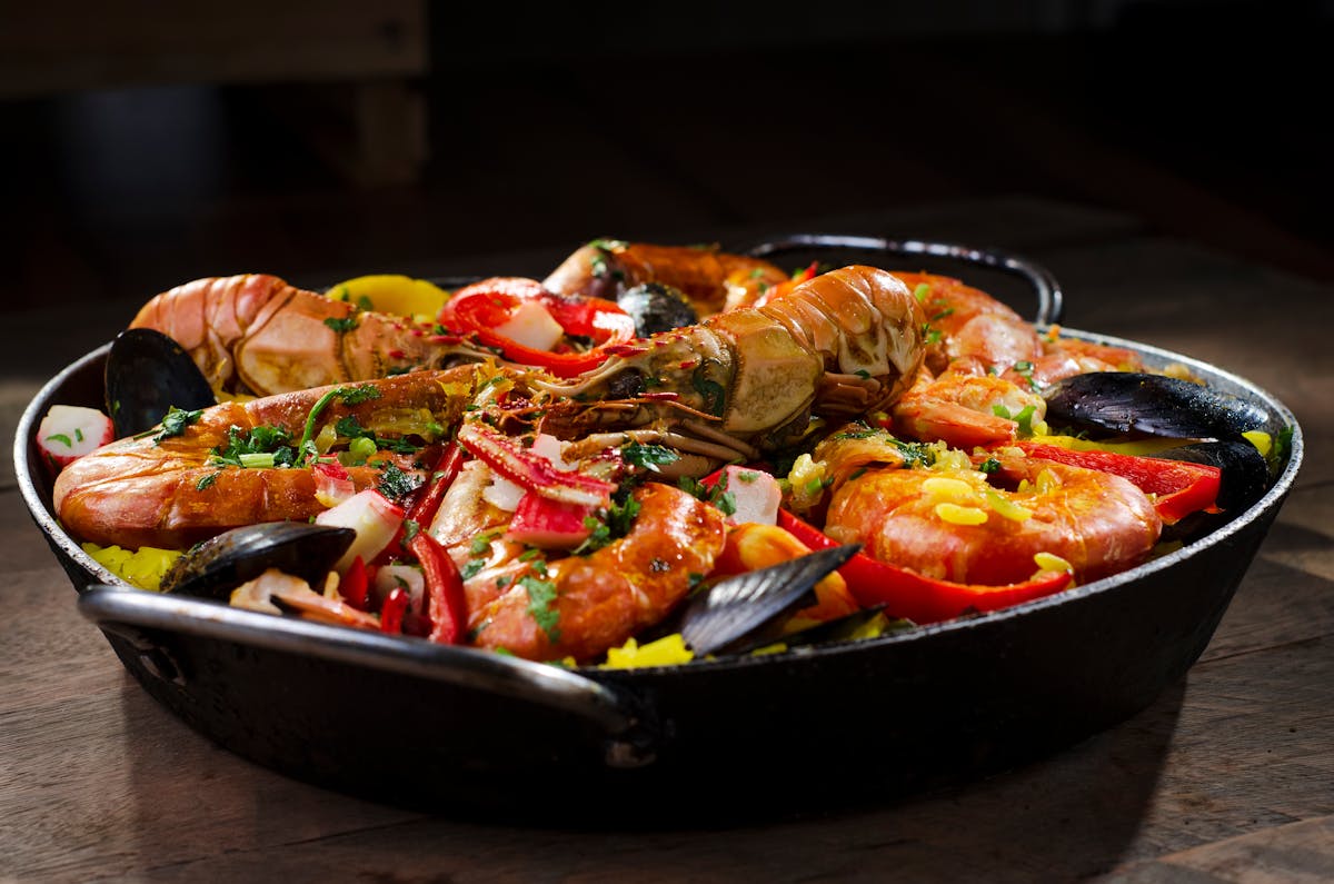 Traditional Barcelona paella marinera with fresh seafood in iconic wide pan featured in Barcelona food guide