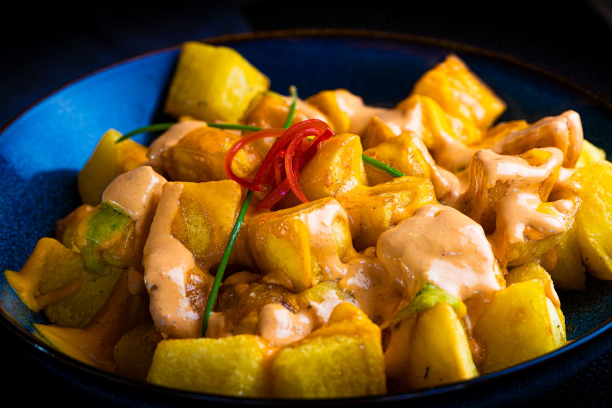 Crispy patatas bravas with sauce, classic Barcelona tapas featured in Barcelona food guide