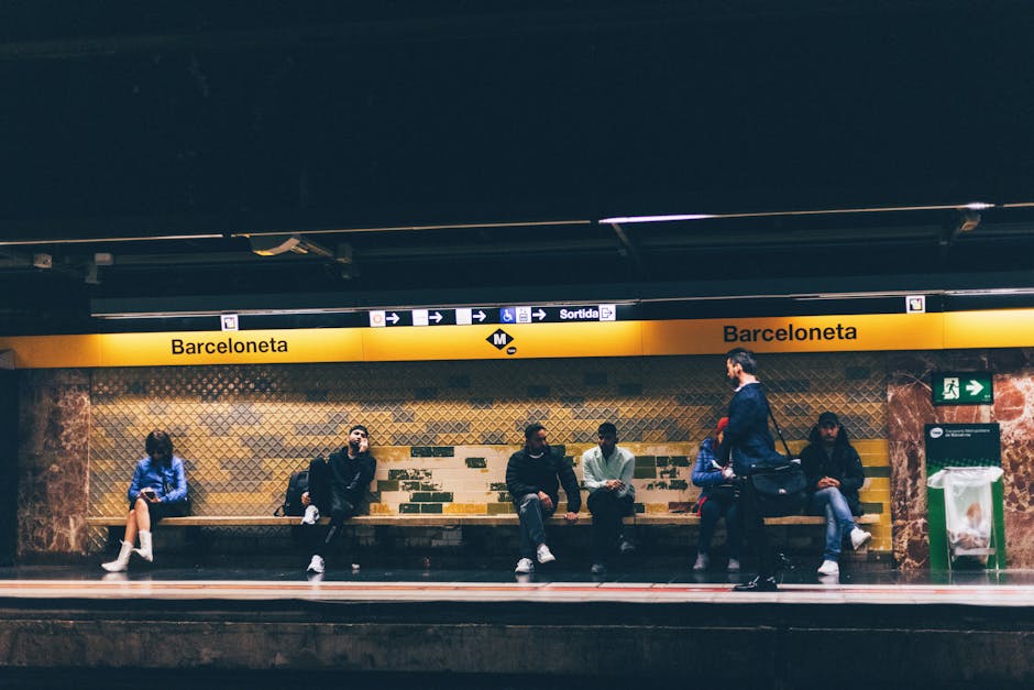 Modern Barcelona metro station platform with a red TMB train arriving