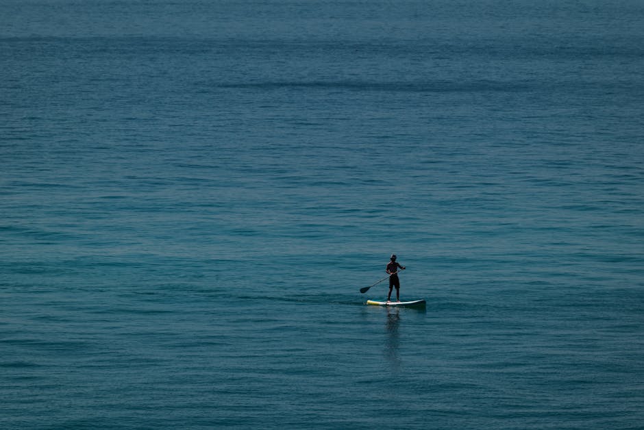 A paddleboarder in calm Mediterranean water along Barcelona's coastline