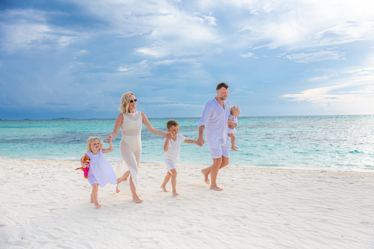 Family enjoying a sunny day at Barcelona beach with kids building sandcastles