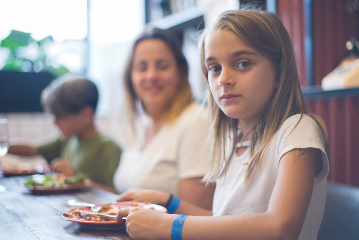 Family enjoying tapas and paella at a terrace restaurant in Barcelona with kids