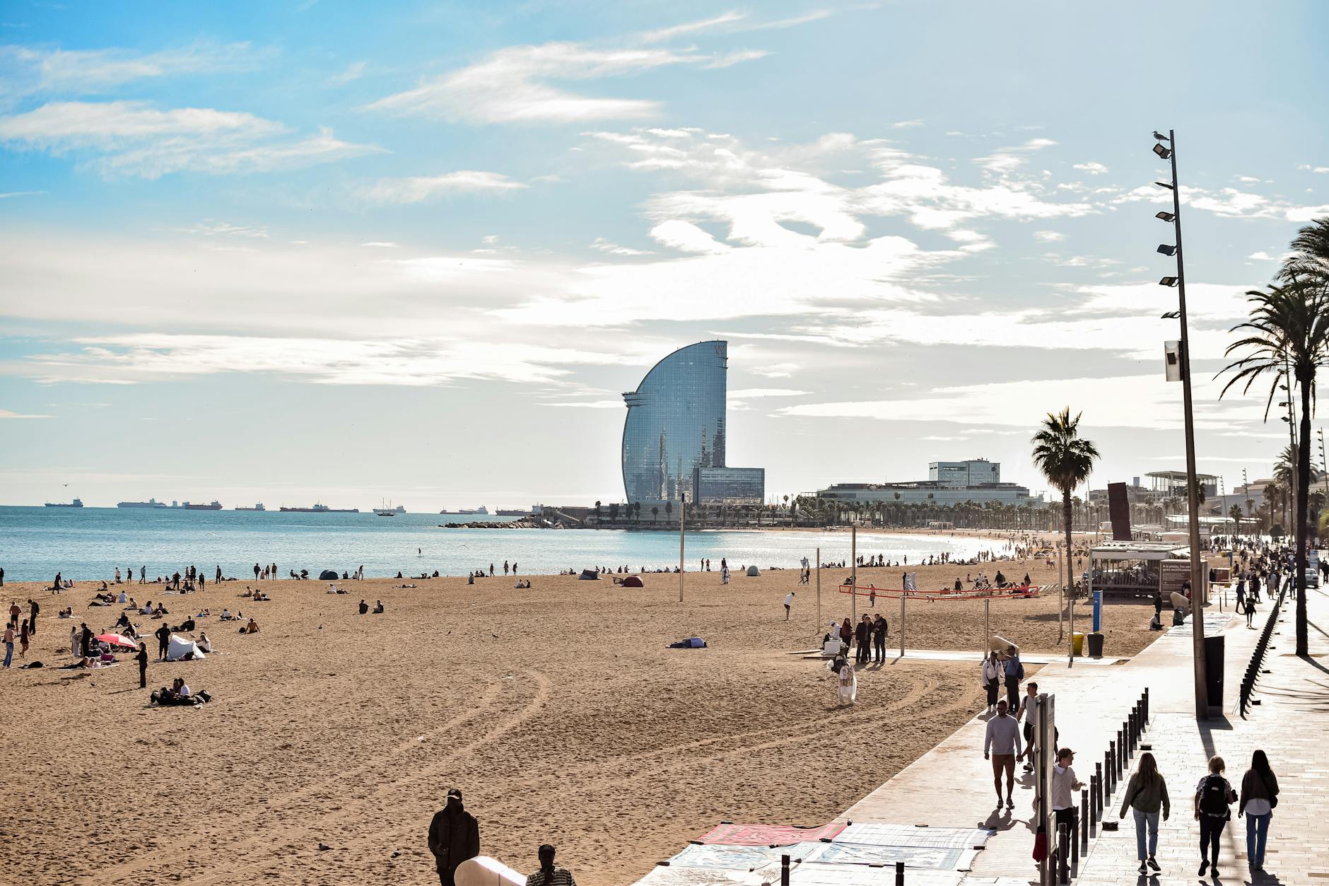 Vibrant day at Barceloneta Beach Barcelona with W Hotel in background