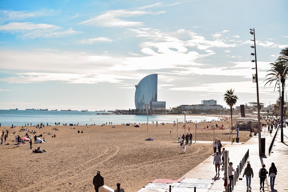 Barceloneta beach in Barcelona with sunbathers, chiringuitos and the W Hotel in the background