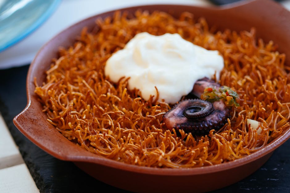 A pan of Catalan fideua with thin pasta noodles, seafood and aioli