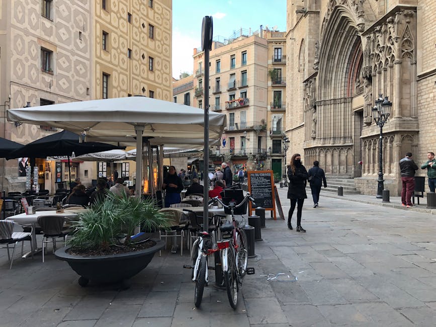A narrow medieval street in El Born Barcelona with hanging lanterns and old stone facades