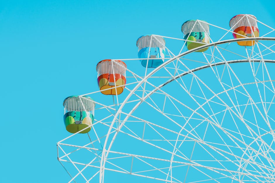 Children riding the historic Ferris wheel at Tibidabo Amusement Park with Barcelona below
