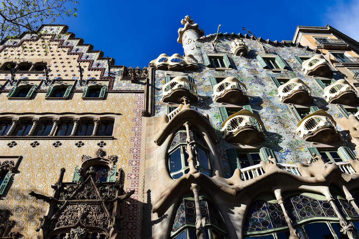 Casa Batllo facade with curved surfaces, colorful tile work, and bone-like iron balconies