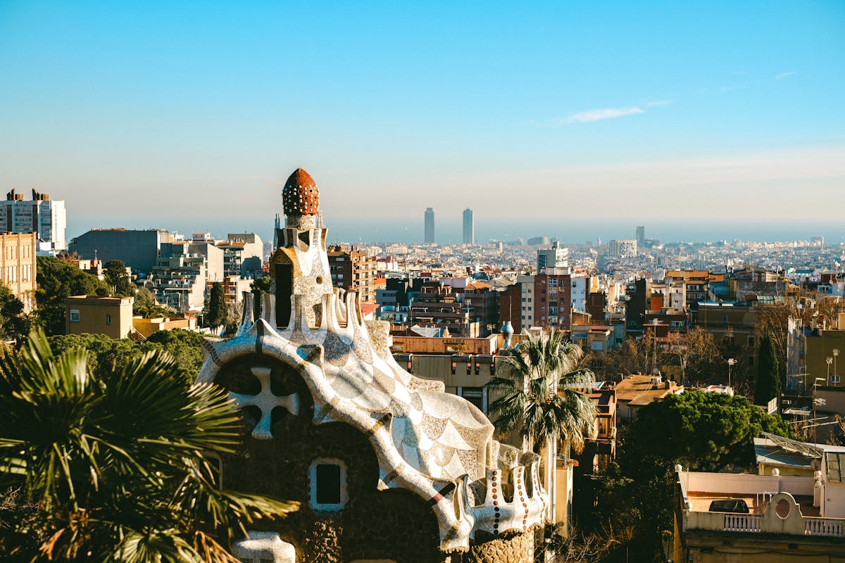 Park Guell terrace with colorful mosaic tiles and Barcelona cityscape view