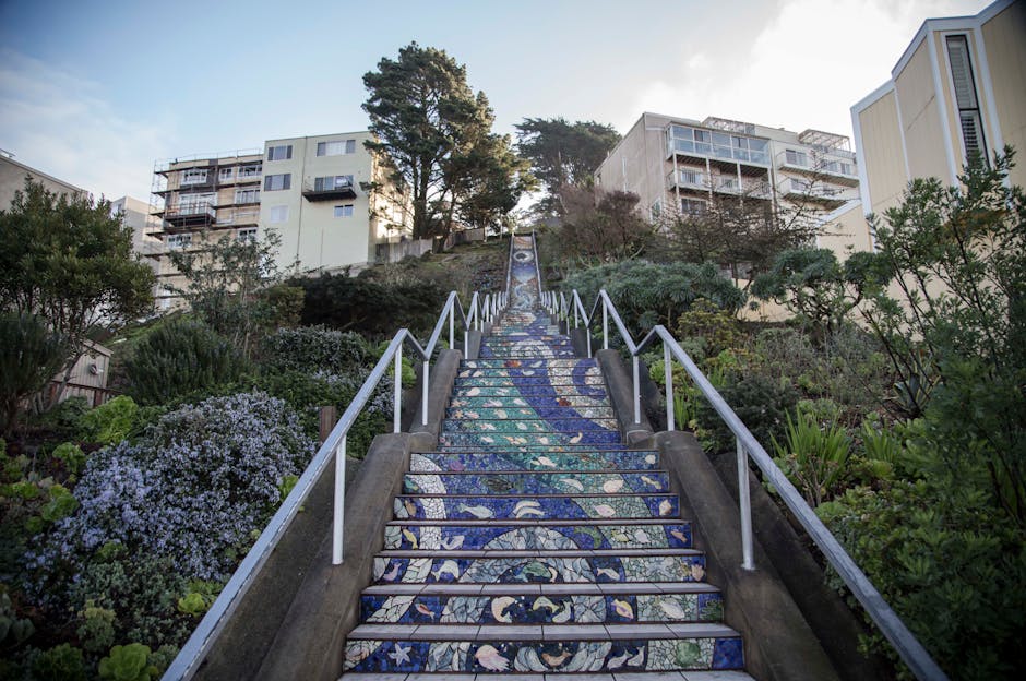 The mosaic dragon staircase at Park Guell with visitors in the background