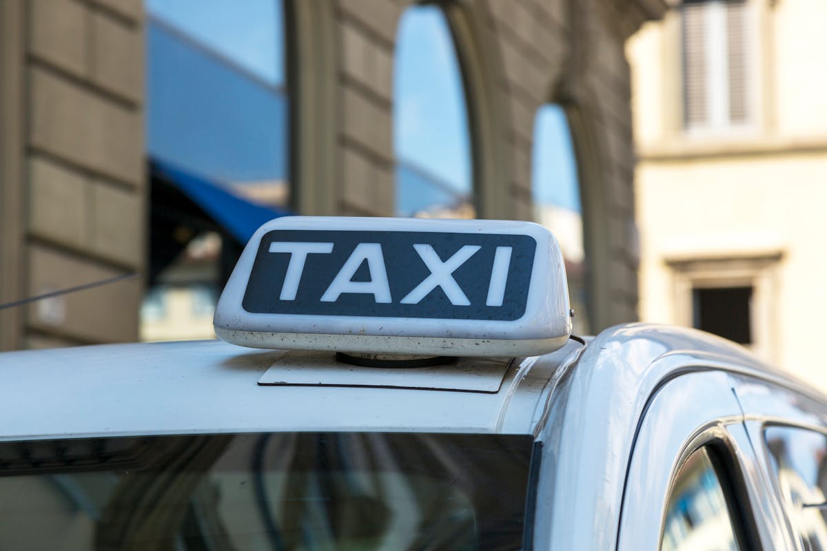 Yellow Barcelona taxi cab at busy intersection with city traffic and urban buildings in background