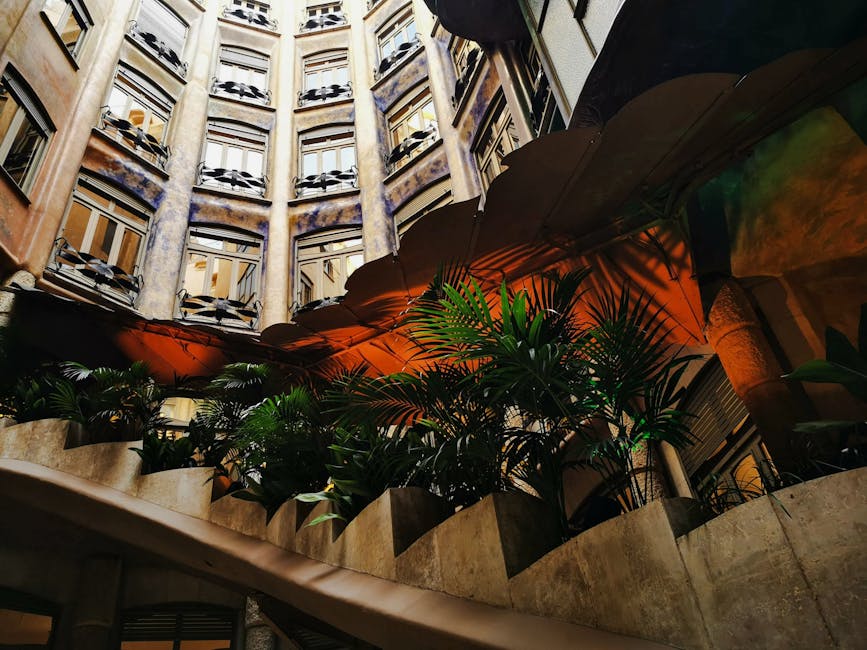 A quiet hidden courtyard in central Barcelona with potted plants and arched windows