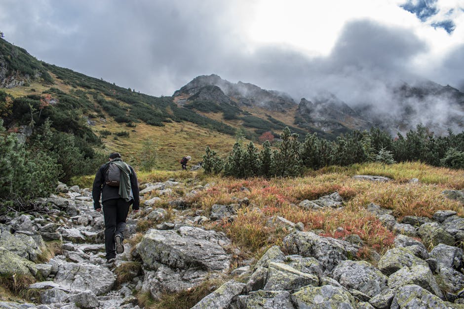 Hikers walking along a stone path on Montserrat with rock formations rising above