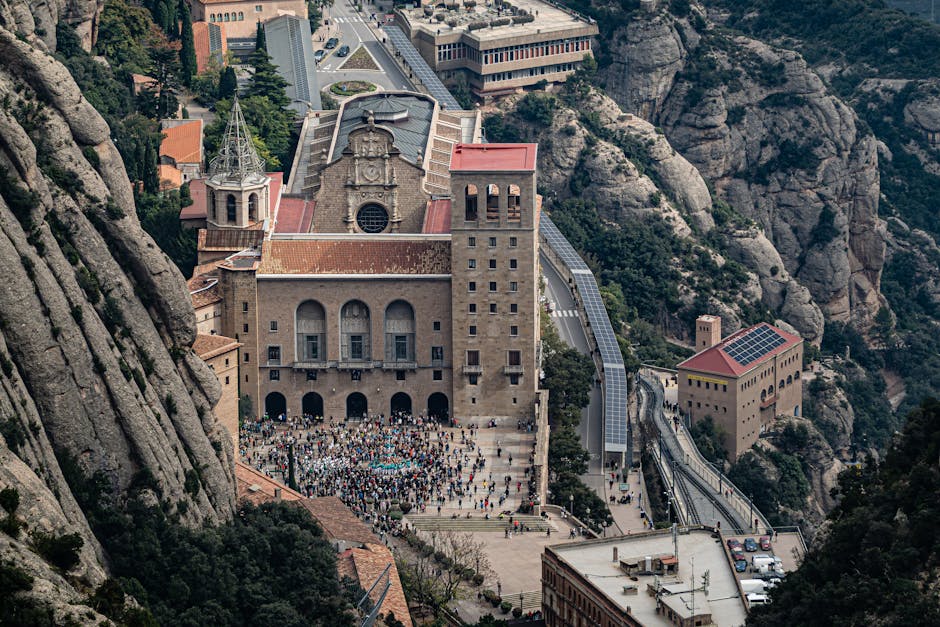 The Santa Maria de Montserrat monastery surrounded by jagged rock formations under a blue sky