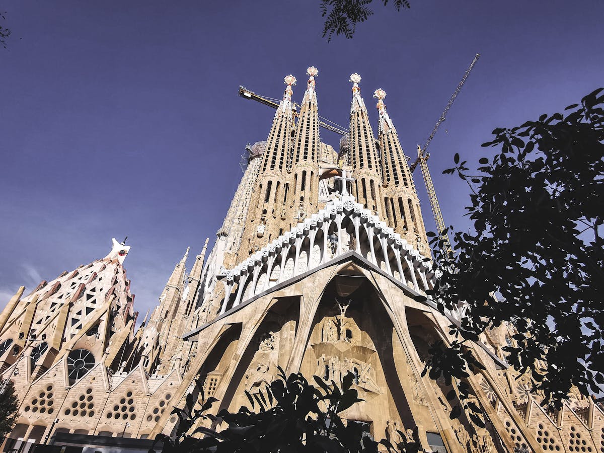 Close-up of the Nativity Facade of the Sagrada Familia showing elaborate stone carvings of figures, animals, and foliage