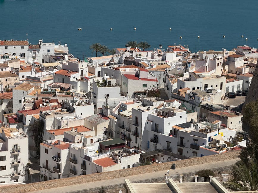 The whitewashed houses of Sitges old town with the church visible at the headland