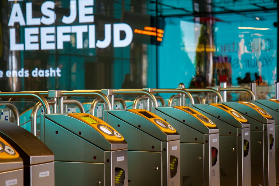A traveller tapping a transit card on a metro turnstile reader at a Barcelona station