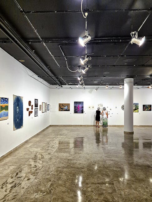 A contemporary art gallery interior with paintings displayed on white walls