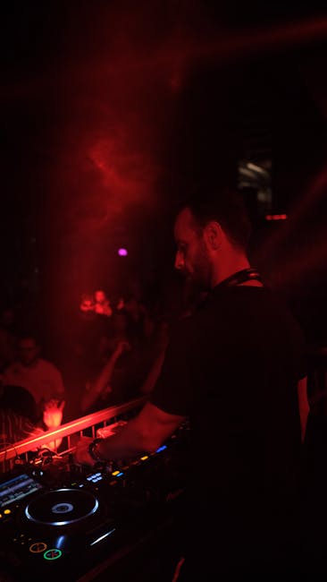 A DJ performing at an electronic music club with mixing equipment
