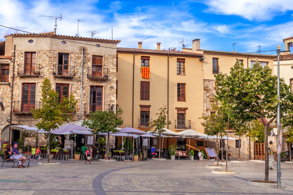 A sunlit plaza in Gracia Barcelona with terrace cafes