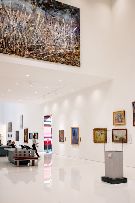 An art museum interior with paintings on the walls and visitors browsing