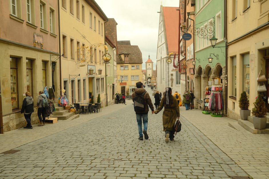 A couple walking hand in hand through a narrow lit Gothic Quarter street at night