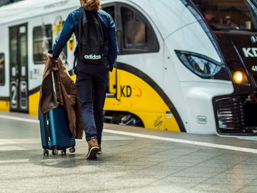 A traveler with suitcase boarding a train at Barcelona Sants station