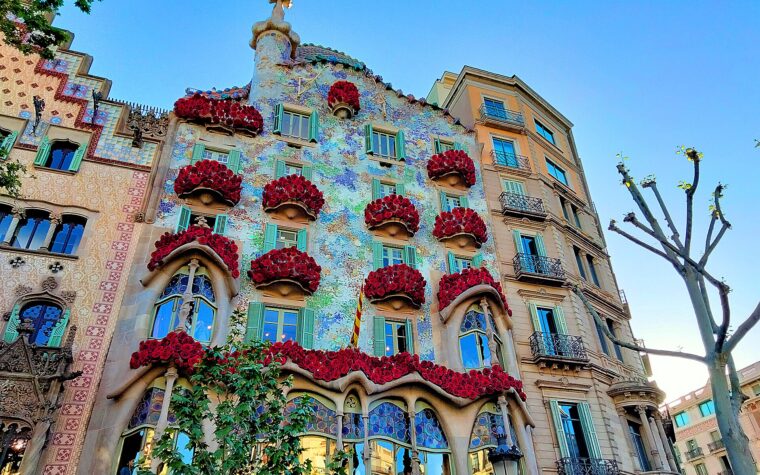 The facade of Casa Batllo on Passeig de Gracia with its balconies covered in red roses for Sant Jordi