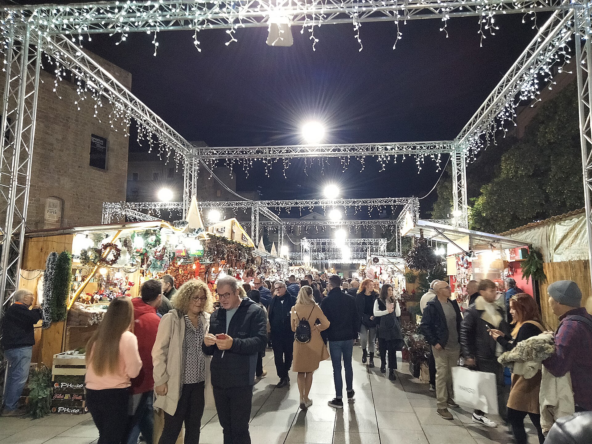 Illuminated wooden stalls at the Fira de Santa Llucia Christmas market beside Barcelona cathedral at night