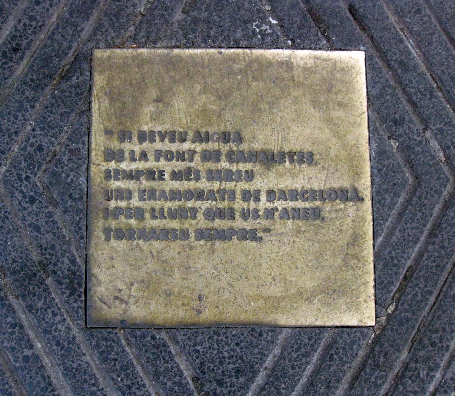 A brass plaque set in the pavement by the Font de Canaletes, inscribed in Catalan with the legend of the fountain