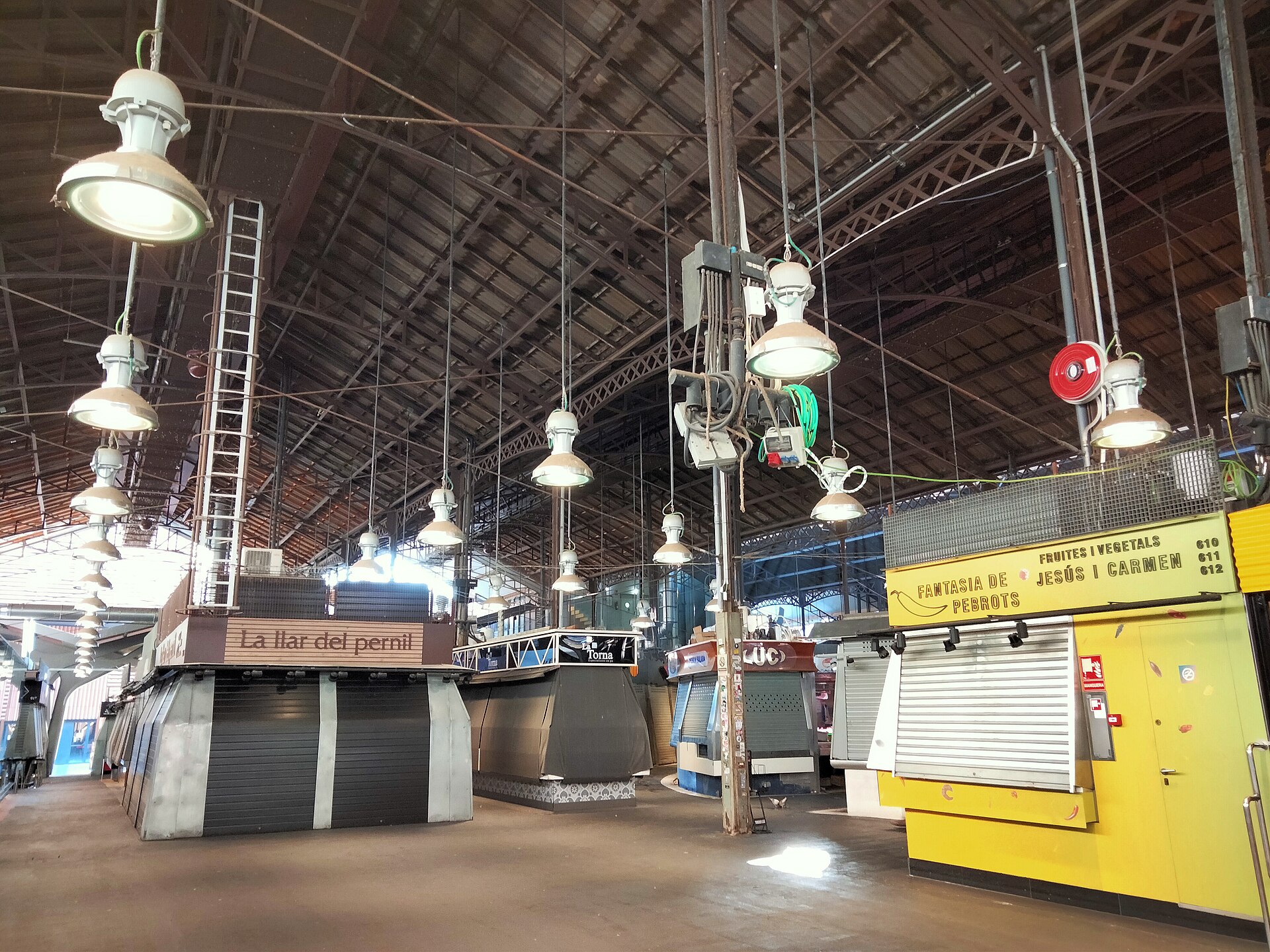 The interior of La Boqueria market with its iron roof and stalls closed behind metal shutters