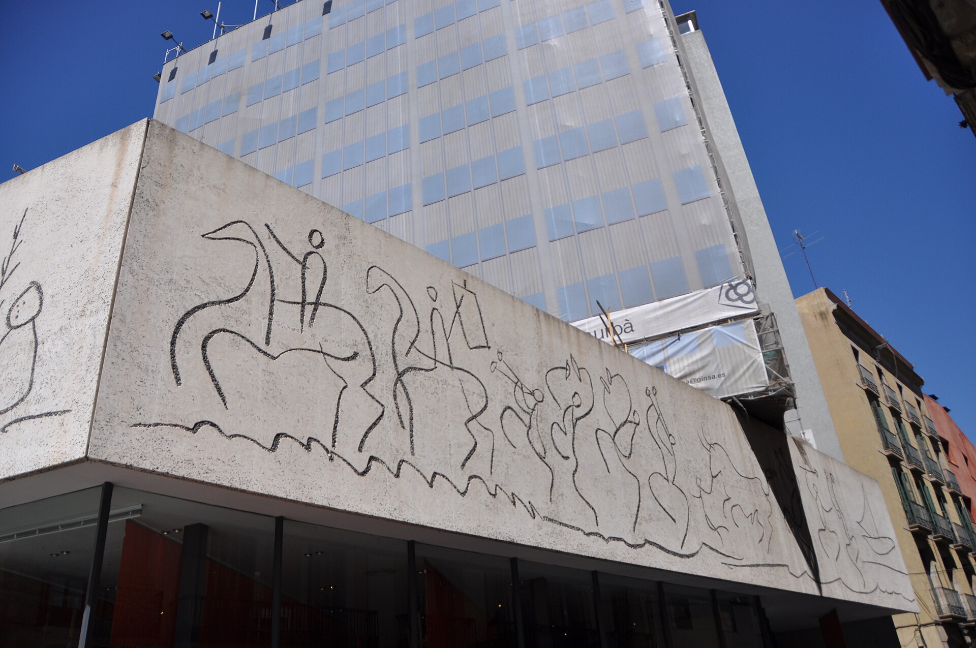 Picasso-designed frieze of horses, riders and musicians cut into the concrete facade of the College of Architects on Placa Nova