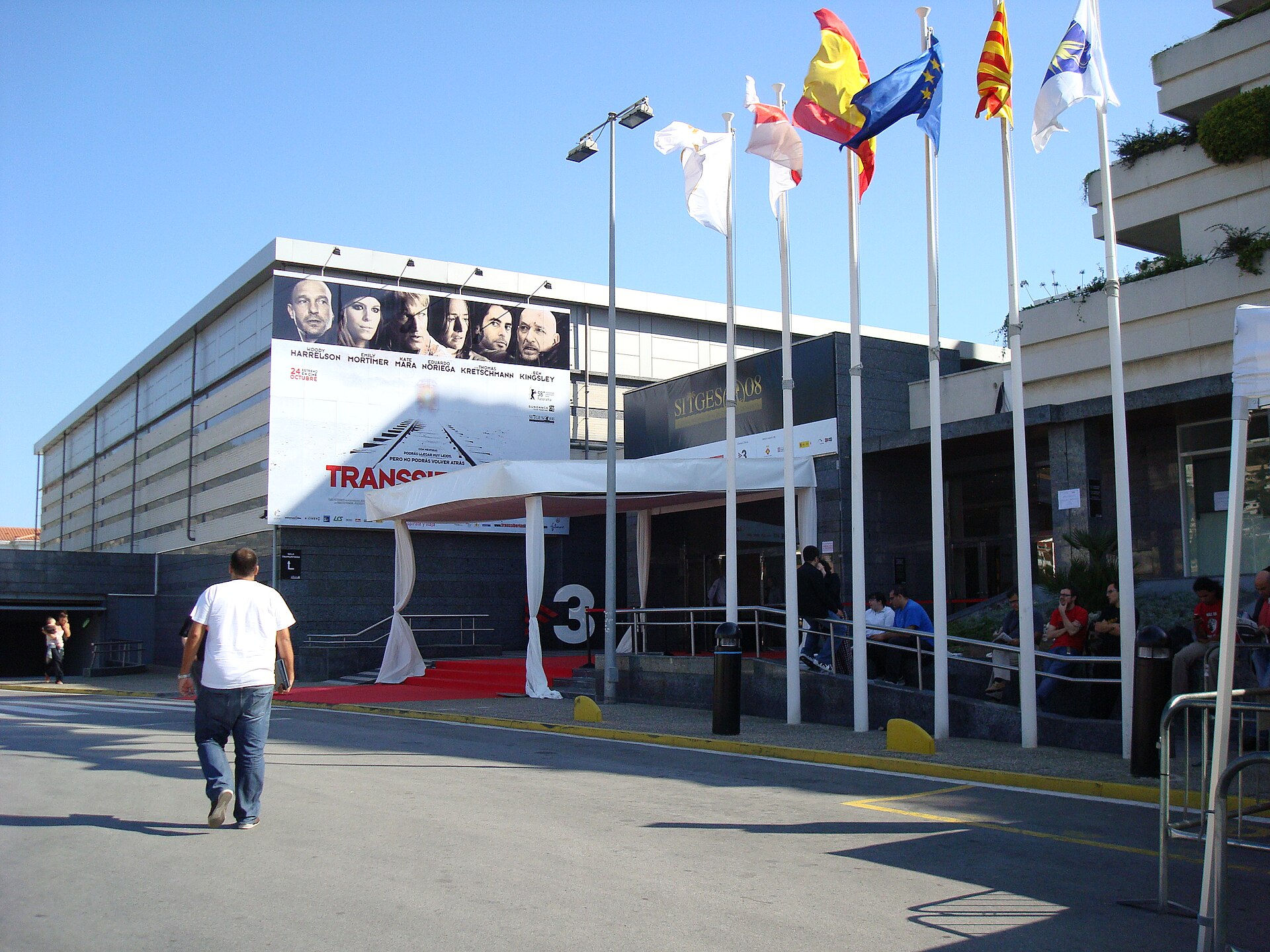 The red carpet and flags outside the main auditorium of the Sitges Film Festival on a sunny day